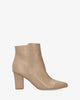 Heeled booties in beige faux leather.