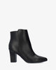 Heeled booties in black faux leather.